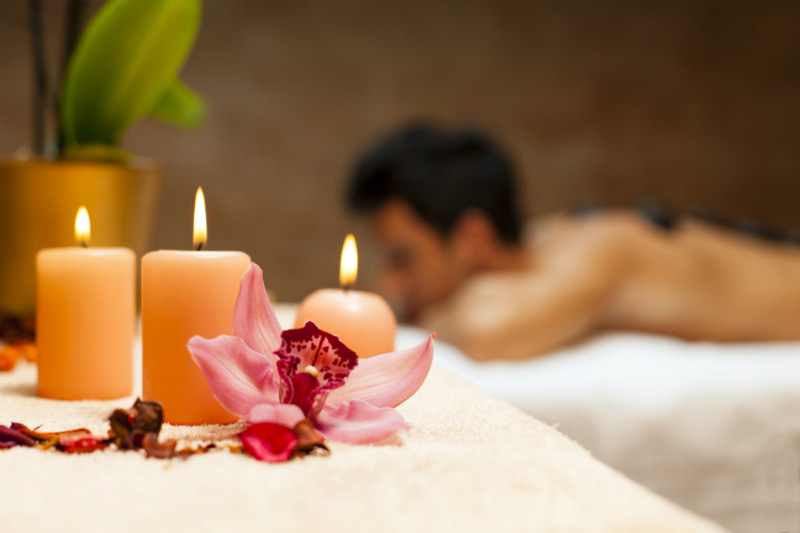 massage for man in a romantic atmosphere with candles and flowers